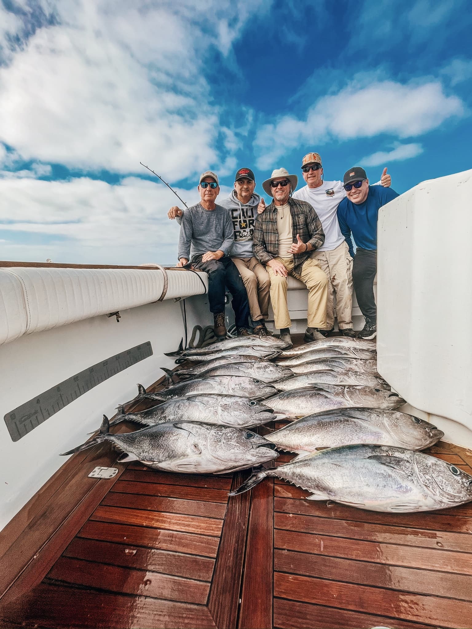 Anglers posing on deck behind their tuna catch