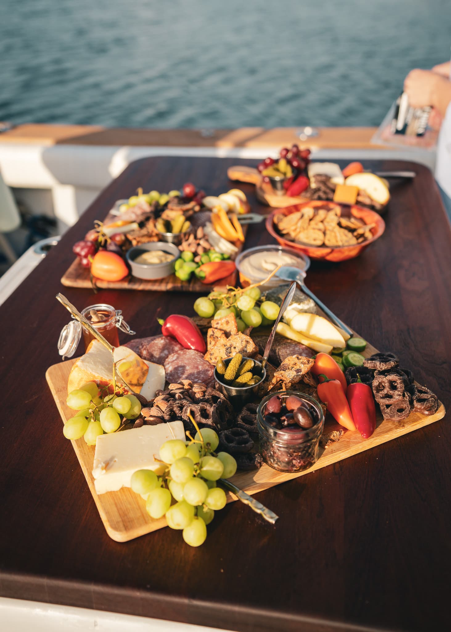 Charcuterie boards served on deck with the ocean behind