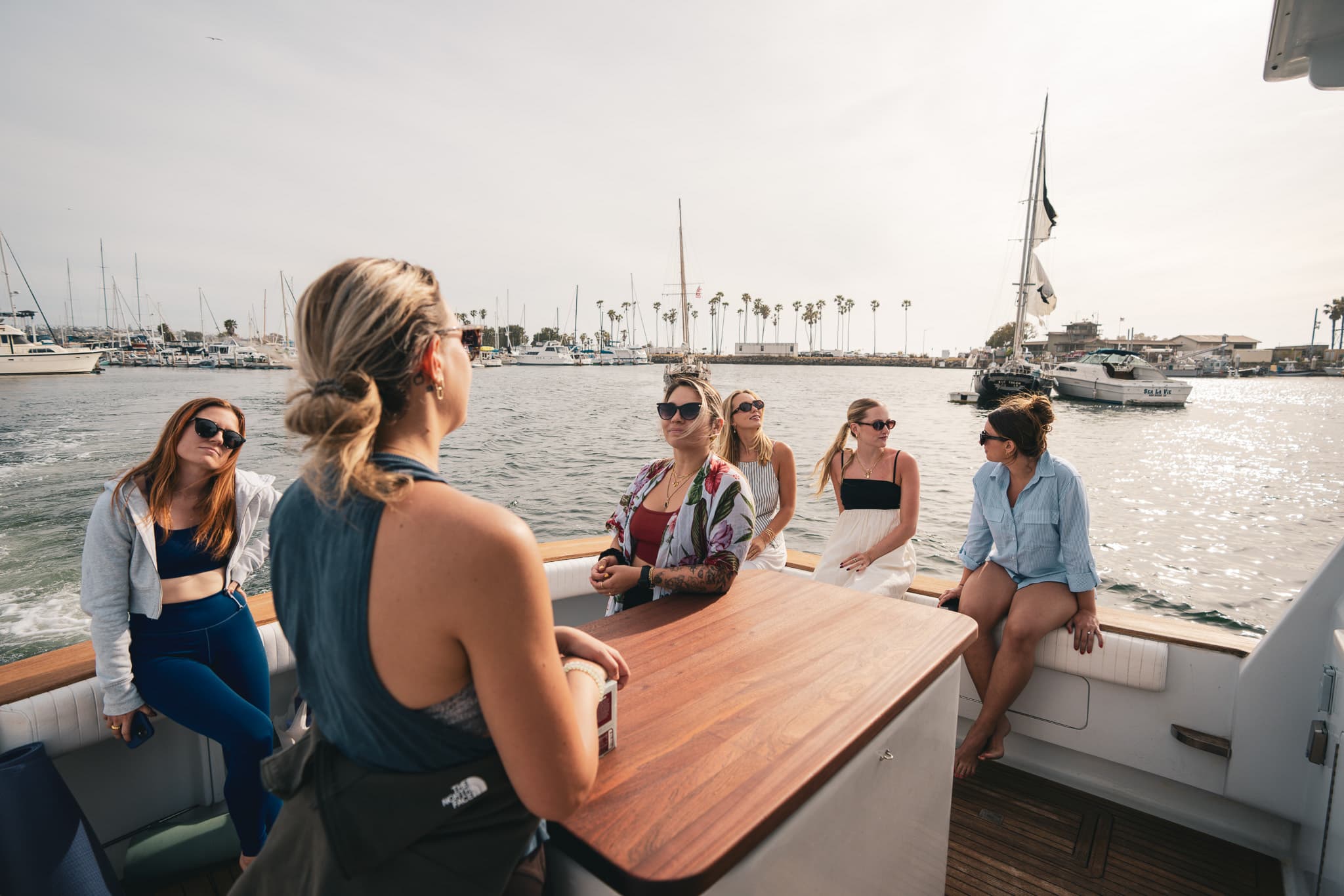 Guests lounging around the aft-deck table as Bluebill motors through the marina
