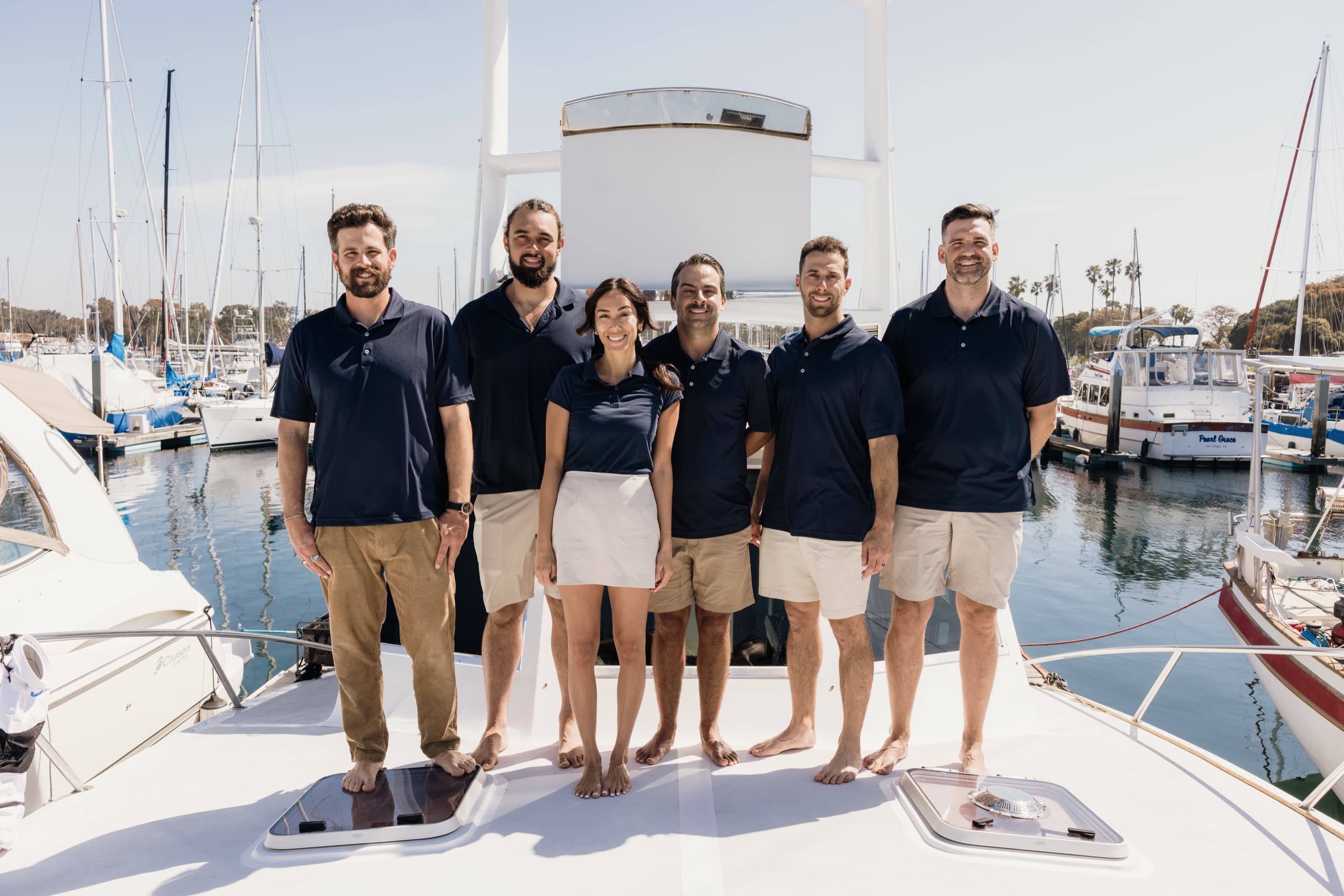 The Bluebill Charters crew standing together on the foredeck in navy polos
