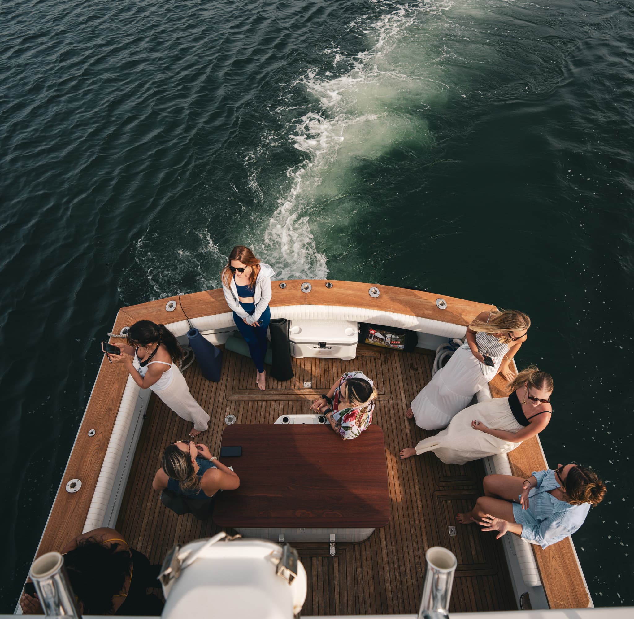 Overhead view of guests on the stern deck with the wake behind